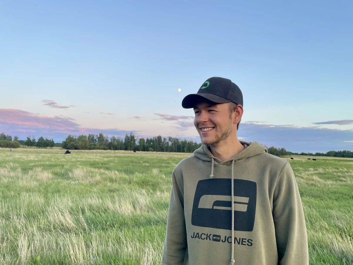 The developer behind Grassland.app and Ranch.Bot standing in pasture.